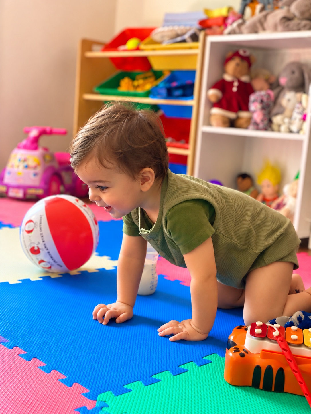 A little explorer smiling and playing on colourful mats at Little Stars Kidz